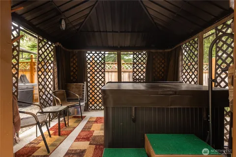 a backyard of a house with wooden floor barbeque oven and outdoor seating