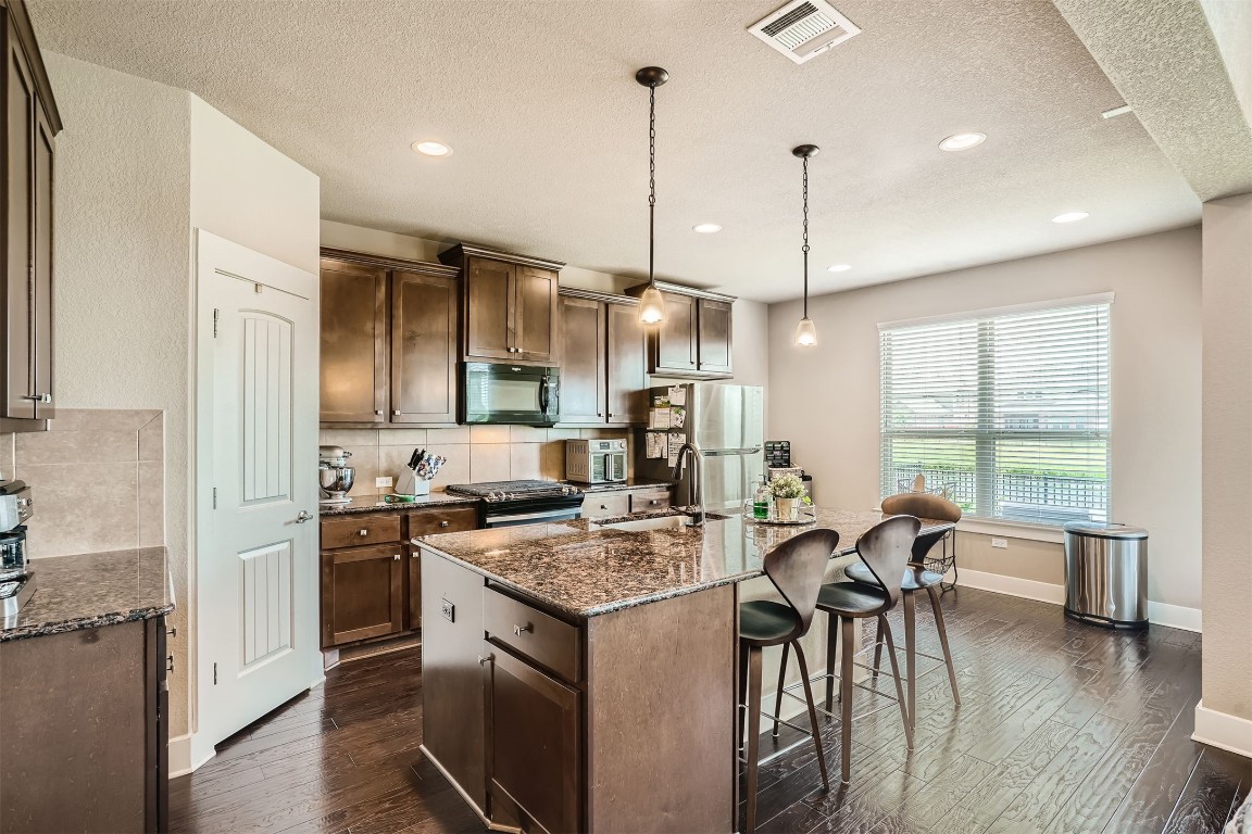 9401 McKnight Loop, Unit 6 Austin, TX 78717 - Photo 11 of 28 a kitchen with a table chairs stove and wooden floor