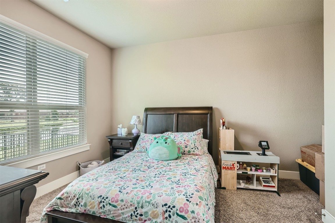 9401 McKnight Loop, Unit 6 Austin, TX 78717 - Photo 17 of 28 a bedroom with a bed and wooden floor