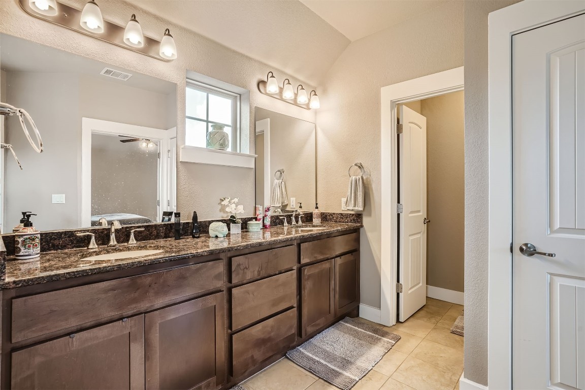 9401 McKnight Loop, Unit 6 Austin, TX 78717 - Photo 20 of 28 a bathroom with a double vanity sink and mirror