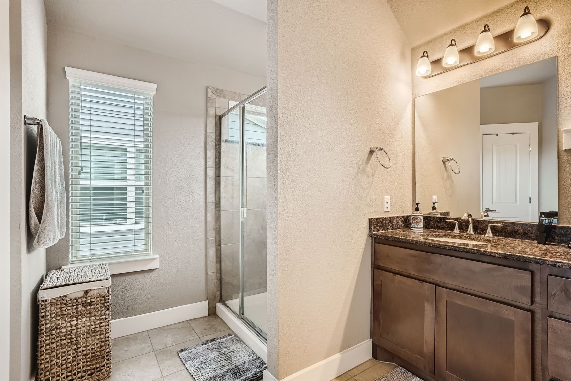 9401 McKnight Loop, Unit 6 Austin, TX 78717 - Photo 21 of 28 a bathroom with a sink a mirror and a shower