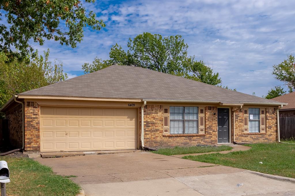 a front view of a house with a garden and yard