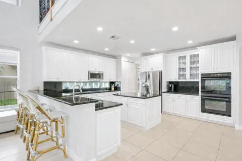 a kitchen with granite countertop a sink and white cabinets