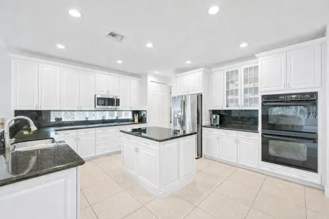 a kitchen with stainless steel appliances granite countertop a stove top oven a sink and cabinets
