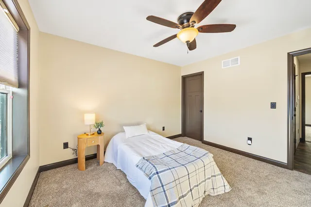 a bedroom with a bed and a ceiling fan