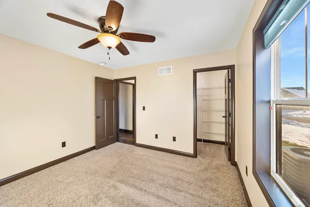 a view of room with a ceiling fan and a large window