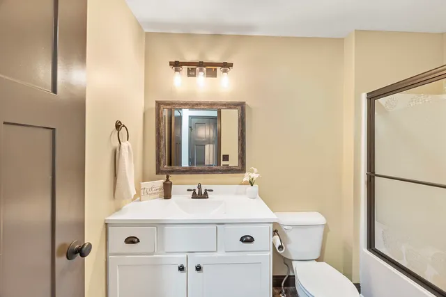 a bathroom with a sink mirror vanity and toilet