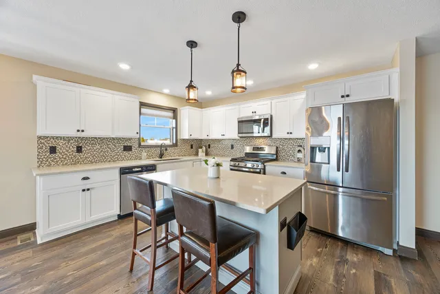 a kitchen with refrigerator cabinets and wooden floor