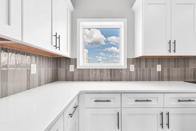 a view of a kitchen with white cabinets