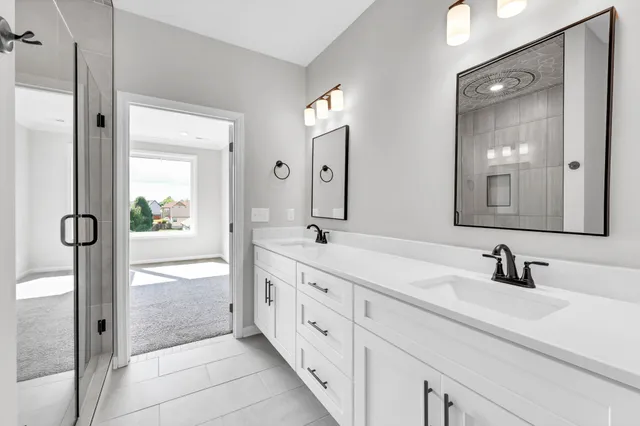 a spacious bathroom with double vanity and mirrors