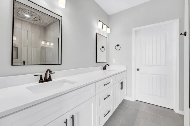 a bathroom with double vanity sink and a mirror