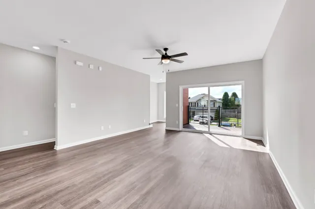 a view of a livingroom with wooden floor and a ceiling fan