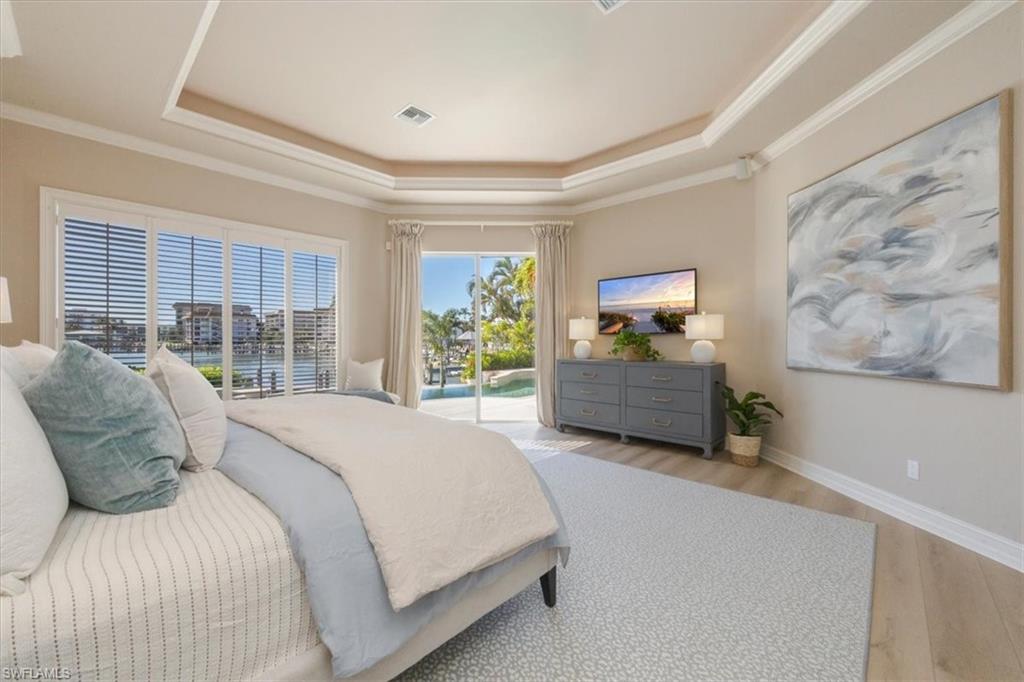 2825 Leeward Lane Naples, FL 34103 - Photo 15 of 44 a bedroom with a large bed and a large window