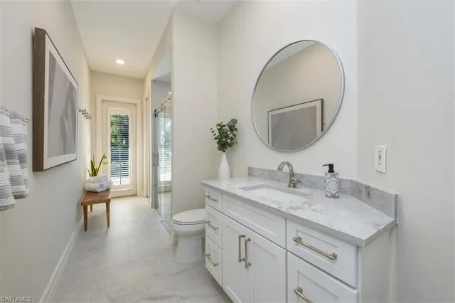 a en suite bathroom with a granite countertop double vanity sink a mirror and a shower