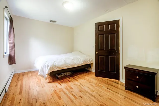 a view of a room with wooden floor and a window