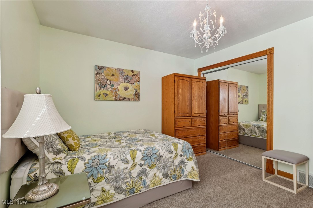 3353 Jens Way Perry, OH 44081 - Photo 27 of 49 Bedroom featuring light colored carpet, a chandelier, and a closet