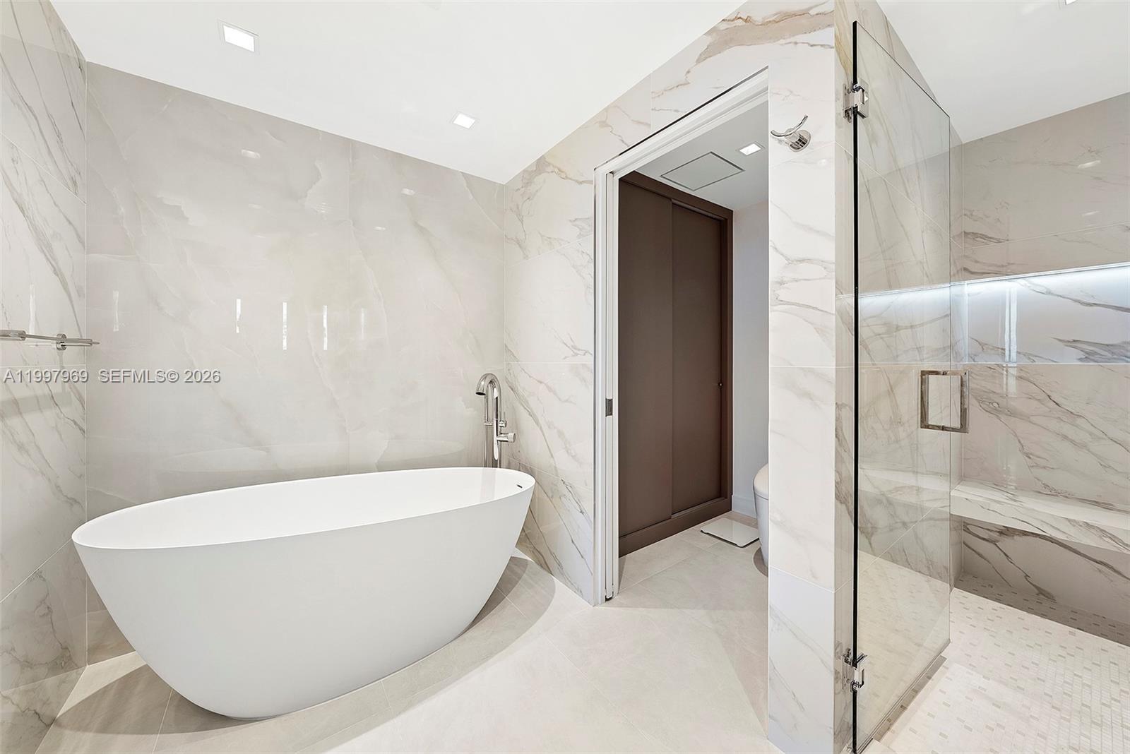 6899 Collins Avenue, Unit 1908 Miami Beach, FL 33141 - Photo 12 of 63 a white bath tub sitting in a bathroom