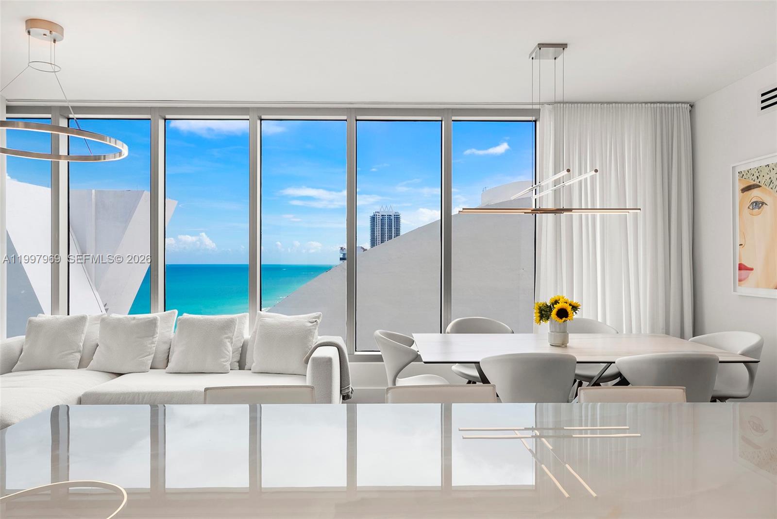 6899 Collins Avenue, Unit 1908 Miami Beach, FL 33141 - Photo 14 of 63 a kitchen with a table chairs and a sink