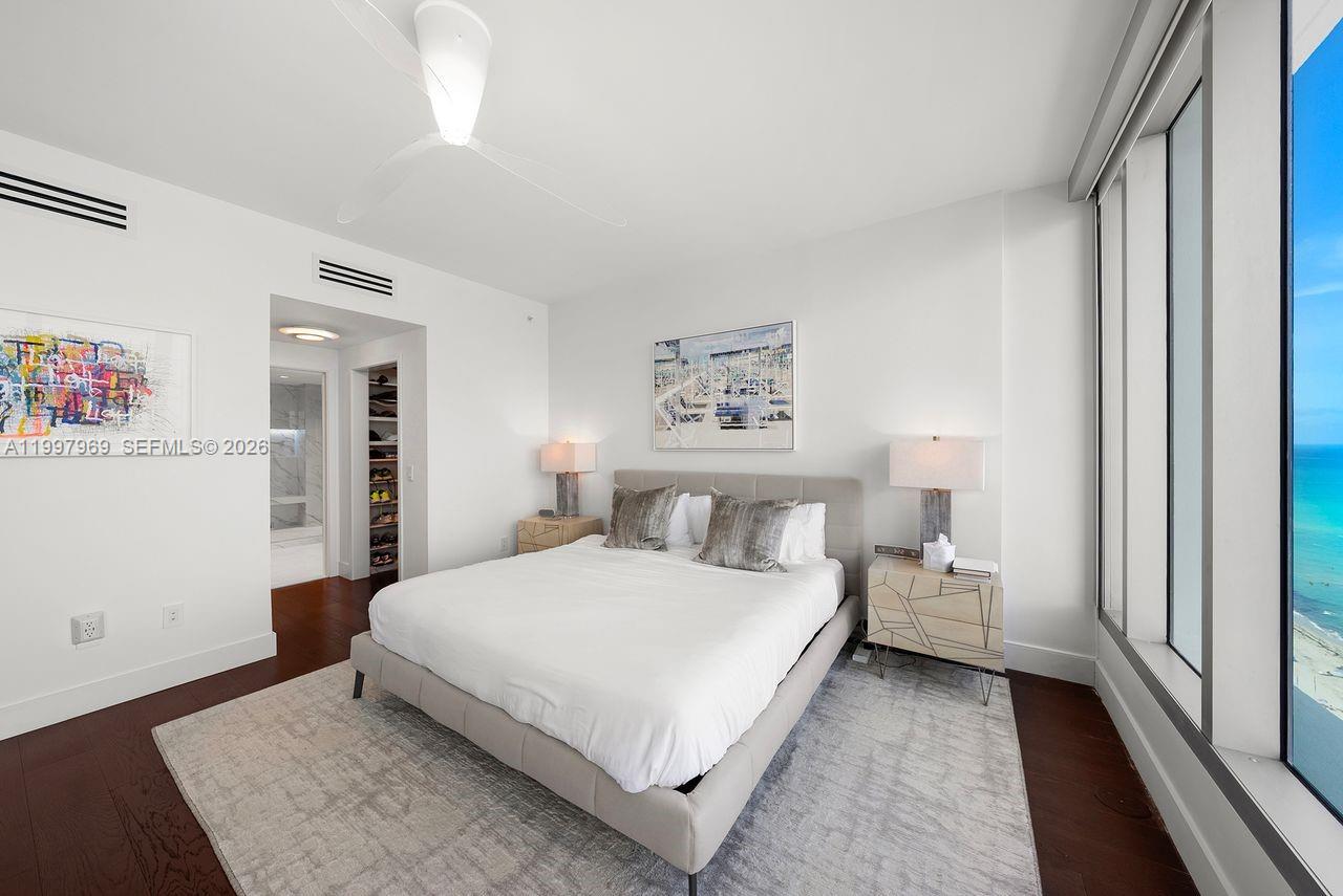 6899 Collins Avenue, Unit 1908 Miami Beach, FL 33141 - Photo 21 of 63 a bedroom with a bed and a night stand