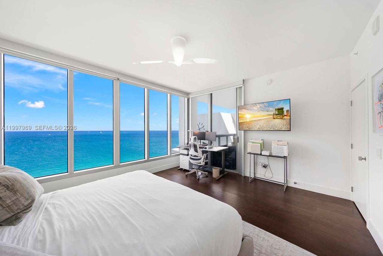 6899 Collins Avenue, Unit 1908 Miami Beach, FL 33141 - Photo 29 of 63 a bedroom with a bed and a flat tv screen on dresser