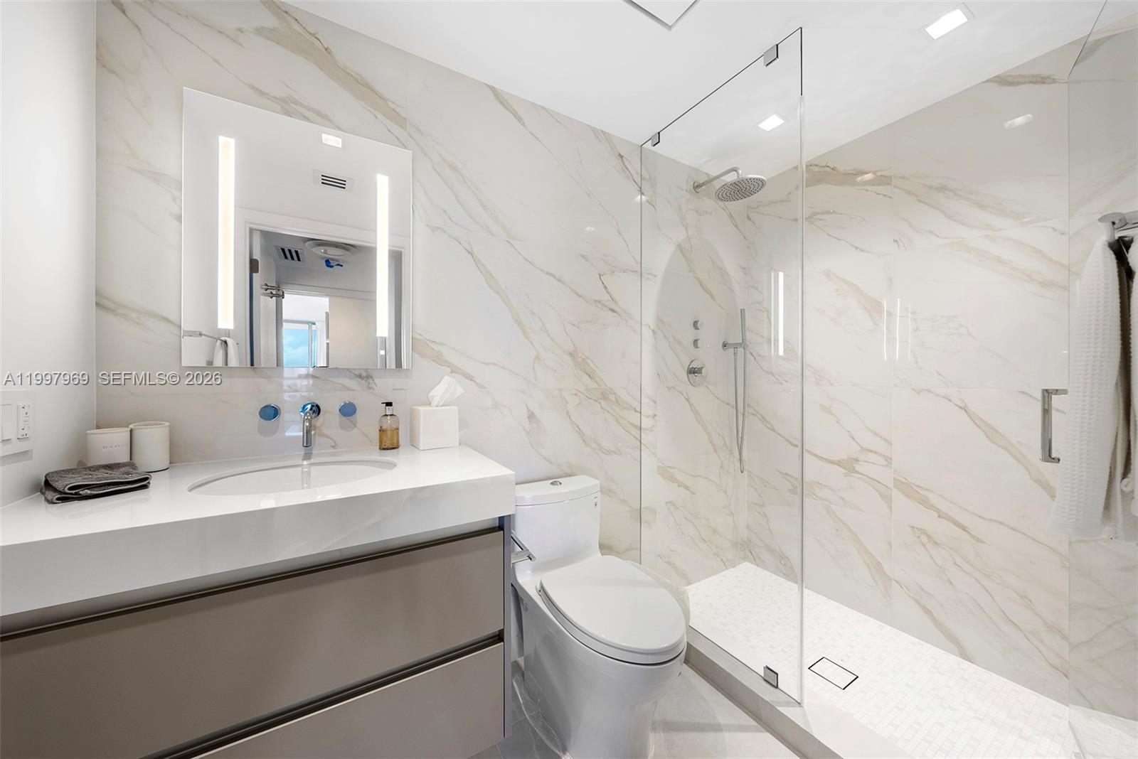 6899 Collins Avenue, Unit 1908 Miami Beach, FL 33141 - Photo 30 of 63 a bathroom with a sink a toilet and shower