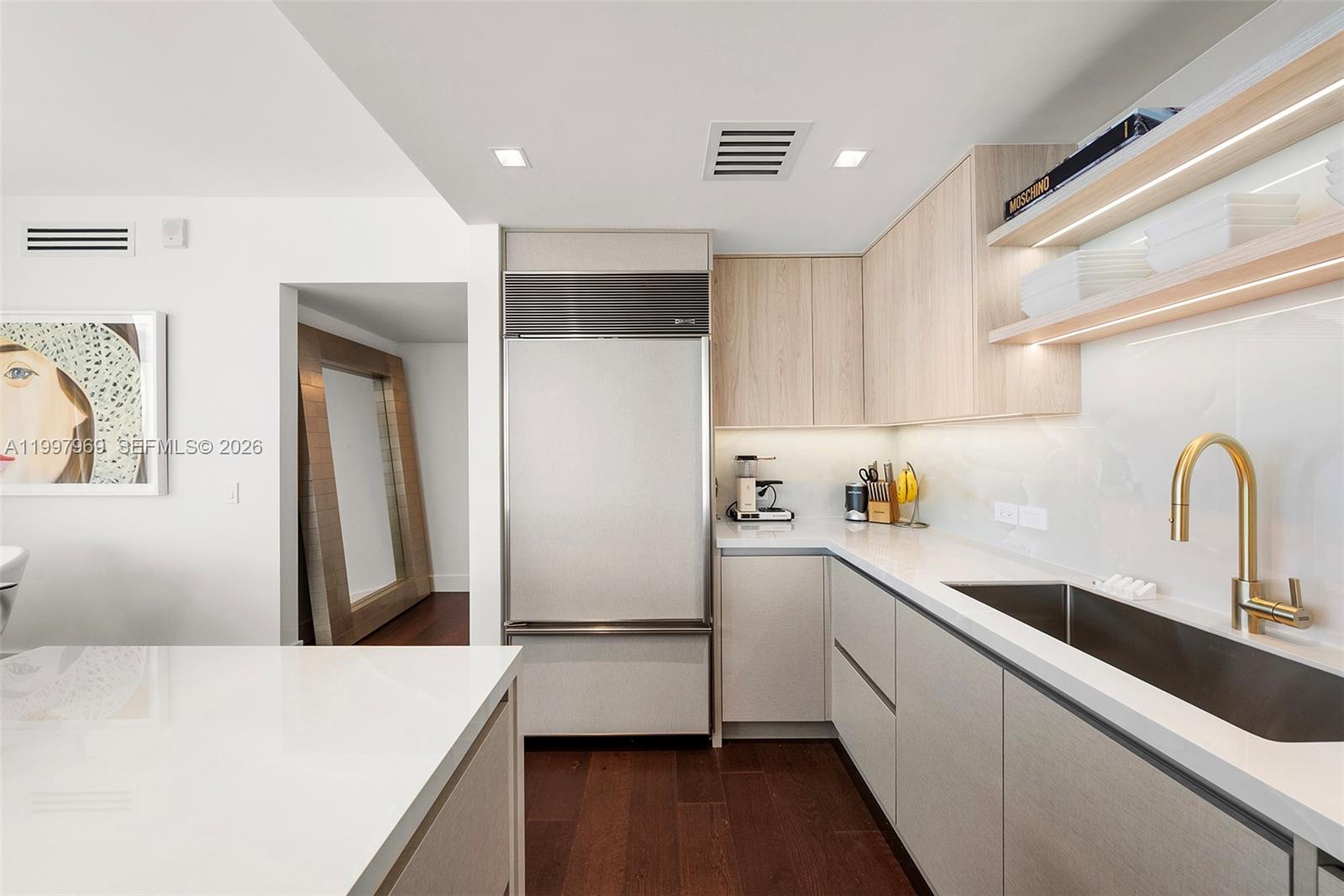 6899 Collins Avenue, Unit 1908 Miami Beach, FL 33141 - Photo 31 of 63 a kitchen with a sink a refrigerator and cabinets