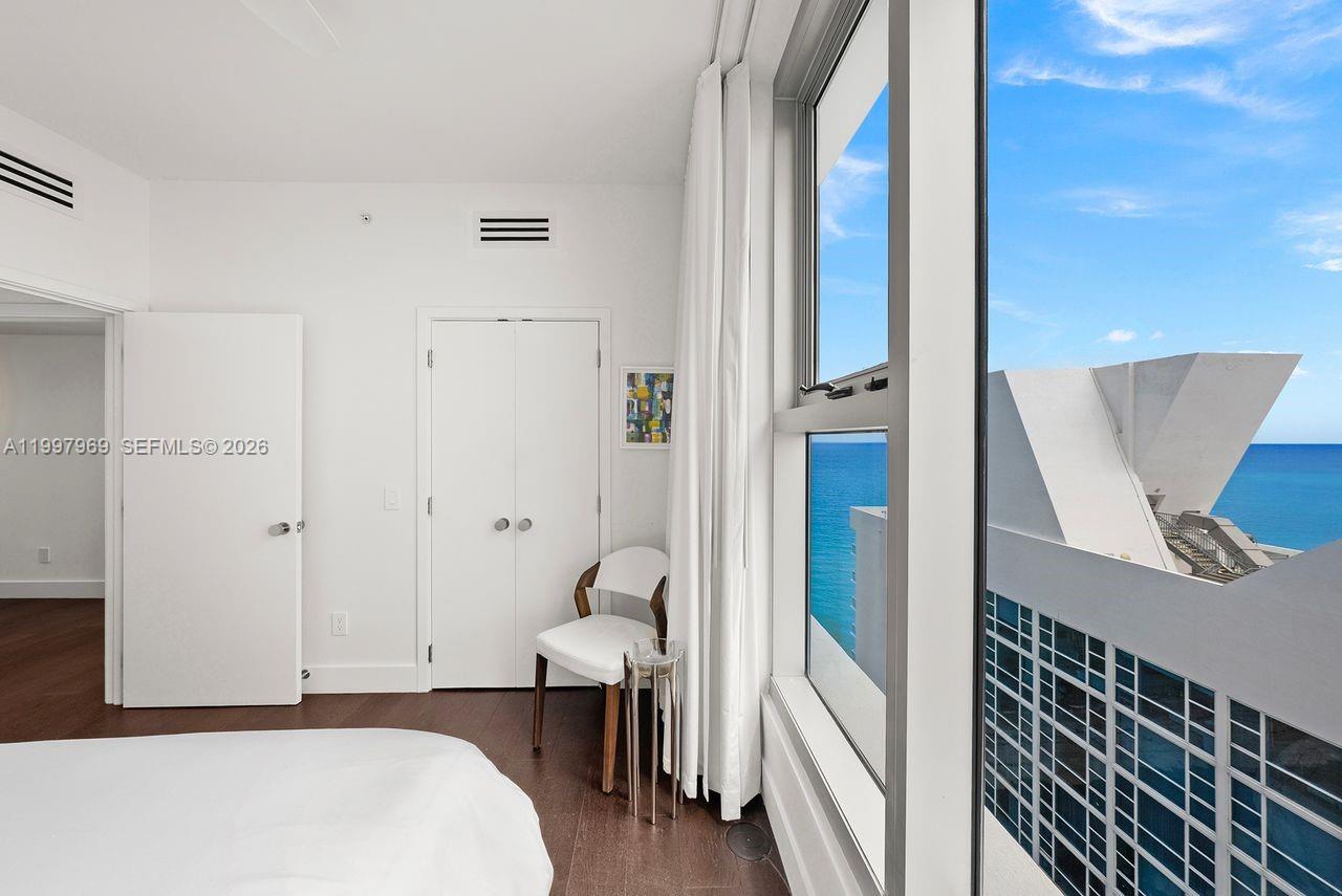 6899 Collins Avenue, Unit 1908 Miami Beach, FL 33141 - Photo 44 of 63 a bedroom with a bed and a book shelf