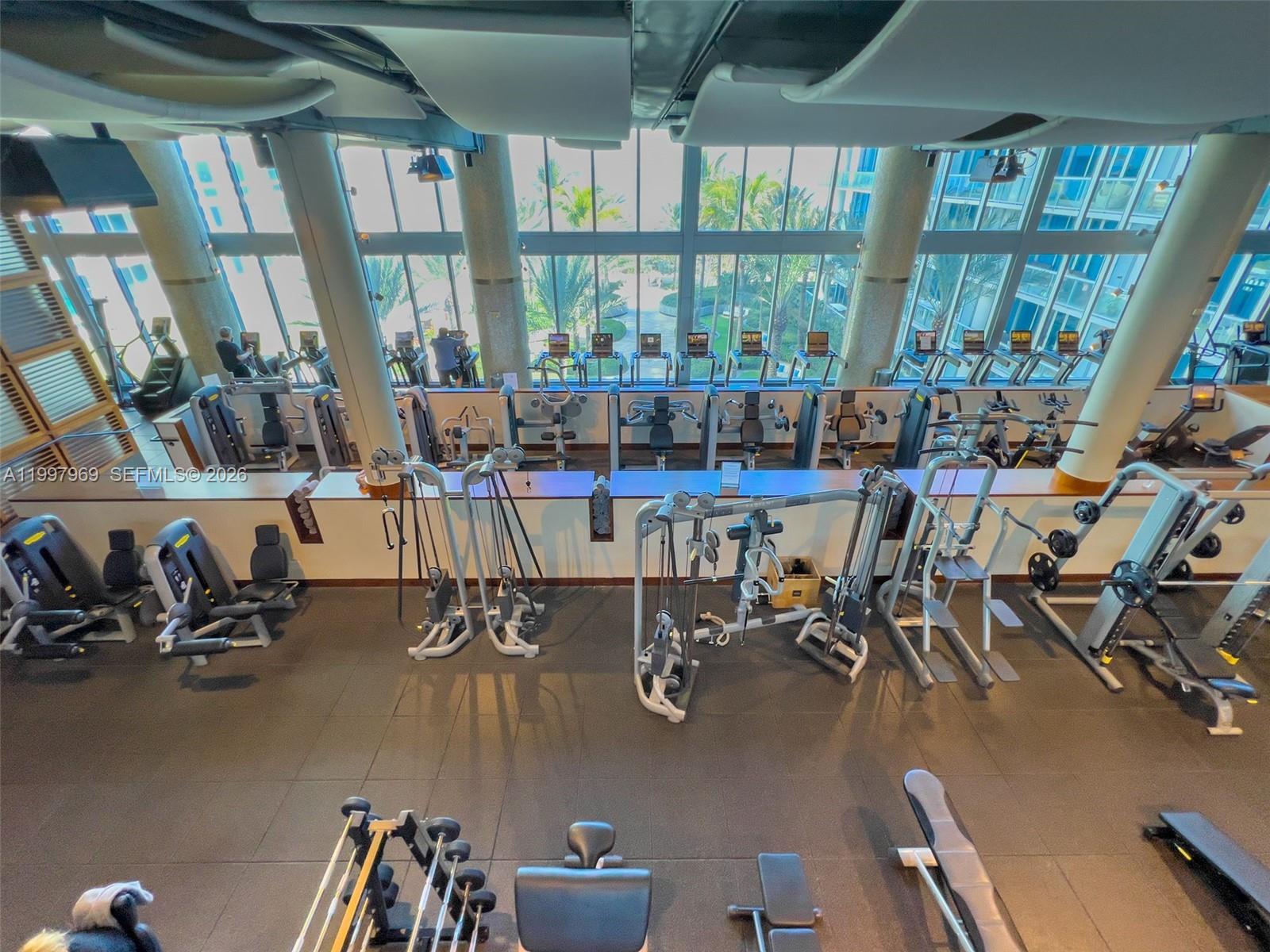 6899 Collins Avenue, Unit 1908 Miami Beach, FL 33141 - Photo 52 of 63 a room with gym equipment and large windows