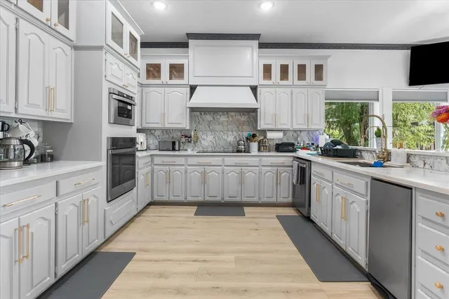 a large kitchen with stainless steel appliances lots of counter space sink and a window