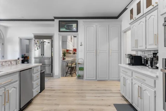 a kitchen with white cabinets and sink