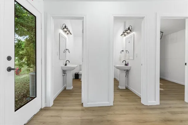 a view of a hallway with wooden floor and a livingroom