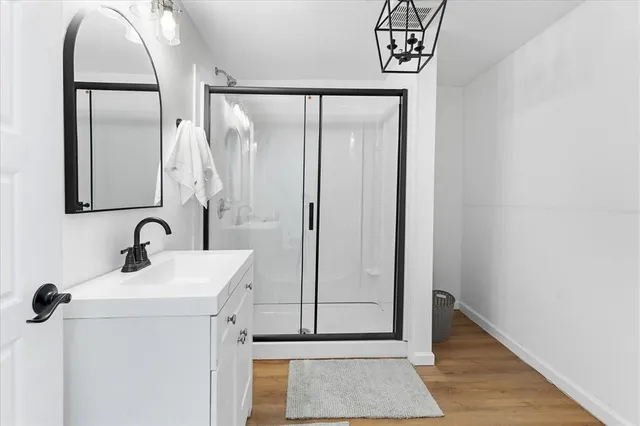 a bathroom with a sink a mirror and shower