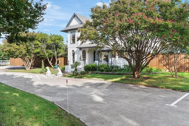 a view of a house with a yard and large tree