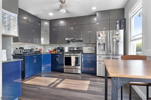 a kitchen with stainless steel appliances granite countertop a stove a sink and a refrigerator