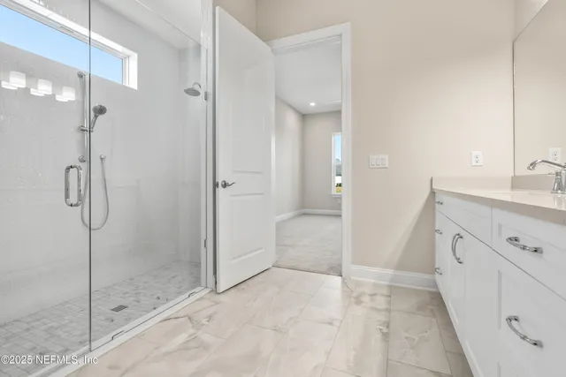 a bathroom with a shower sink and mirror