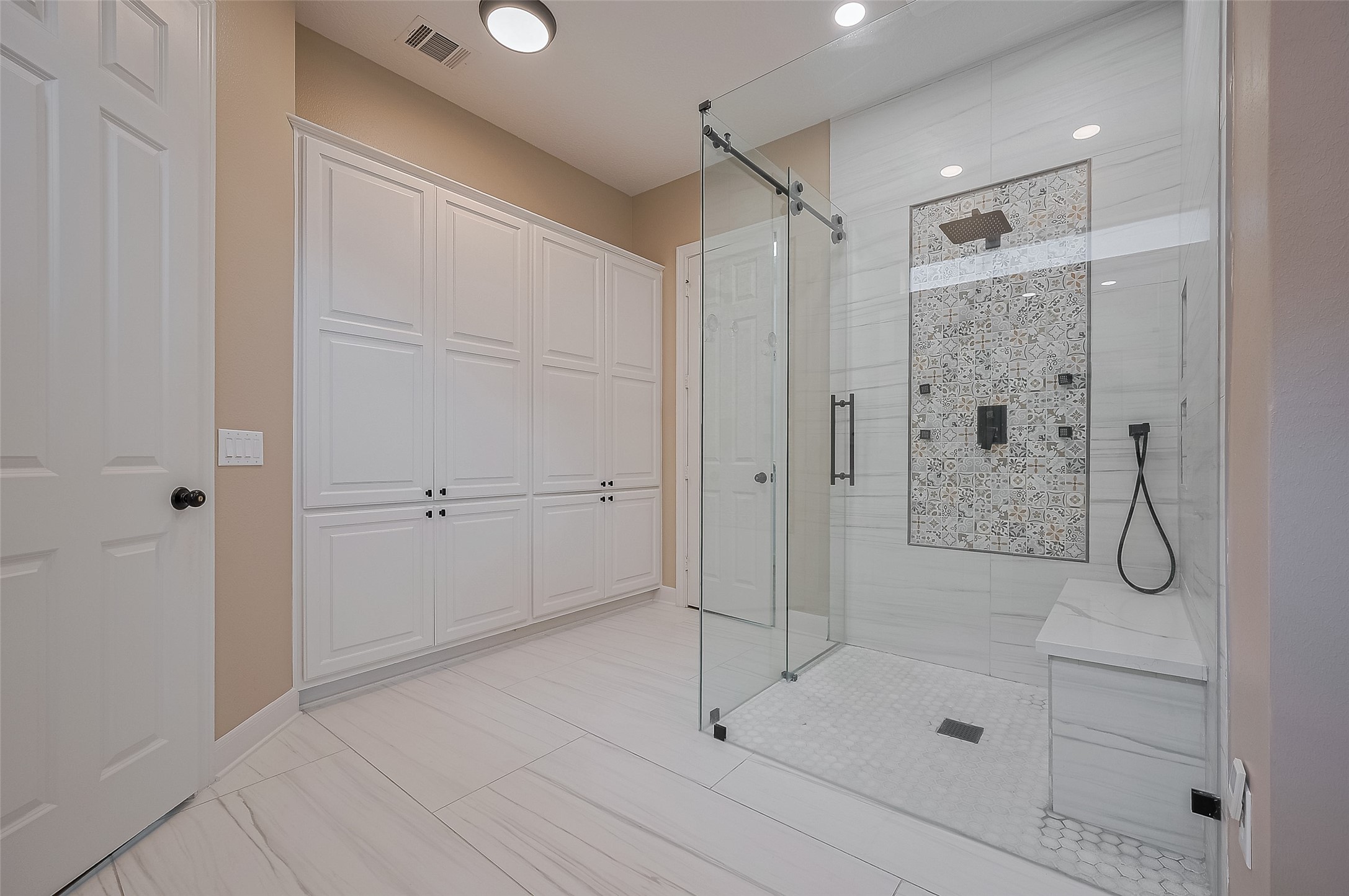 11826 Legend Manor Drive Houston, TX 77082 - Photo 34 of 43 This is the show stopper! Frameless walk-in closer with multiple shower heads Cabinets provide plenty of linen storage. NOT SHOWN: In addtion, a free standing tub going in Nov/2025.