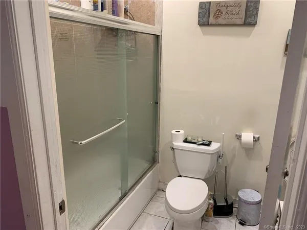 a white toilet sitting next to a shower