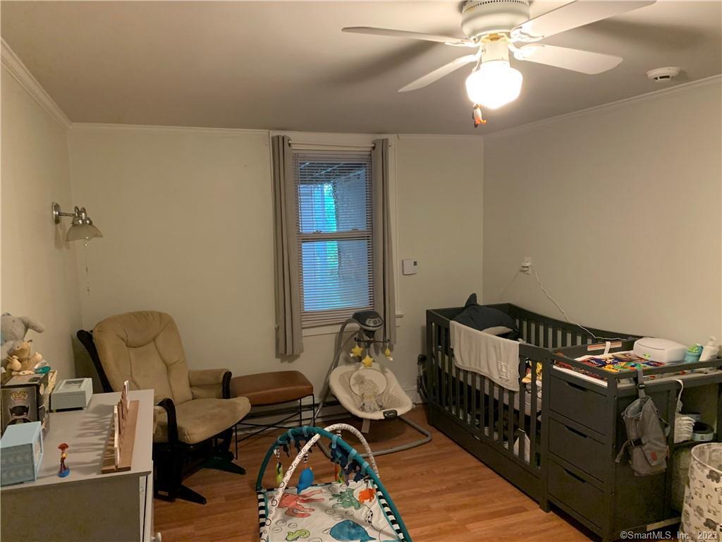 15 Spring Hill Avenue Norwalk, CT 06850 - Photo 15 of 18 a bedroom with furniture and a chandelier