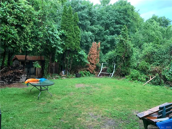 a view of a backyard with table and chairs and a slide