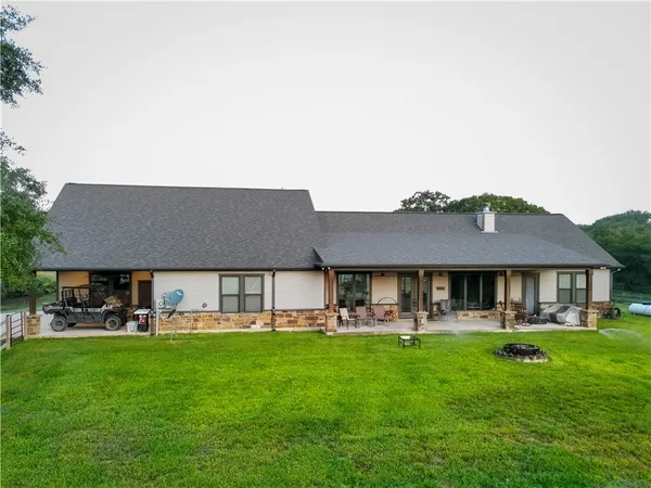 a front view of a house with a garden and trees