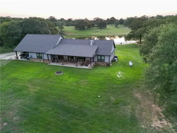 an aerial view of a house with pool table and large trees