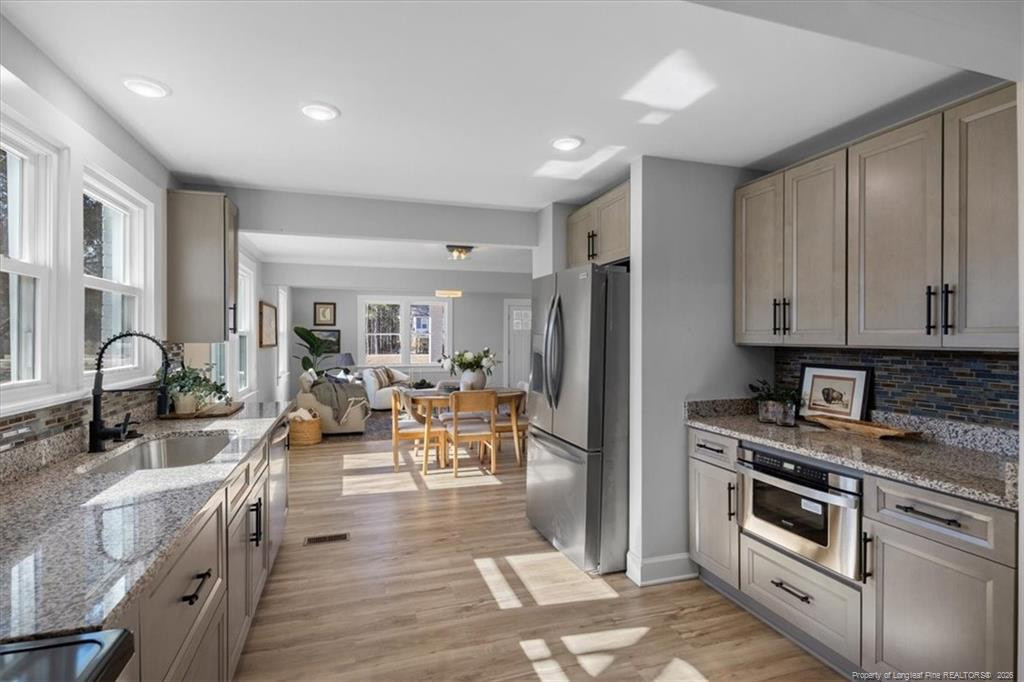 146 Union Church Road Carthage, NC 28327 - Photo 6 of 19 a kitchen with stainless steel appliances granite countertop a stove top oven a sink dishwasher a dining table and chairs with wooden floor