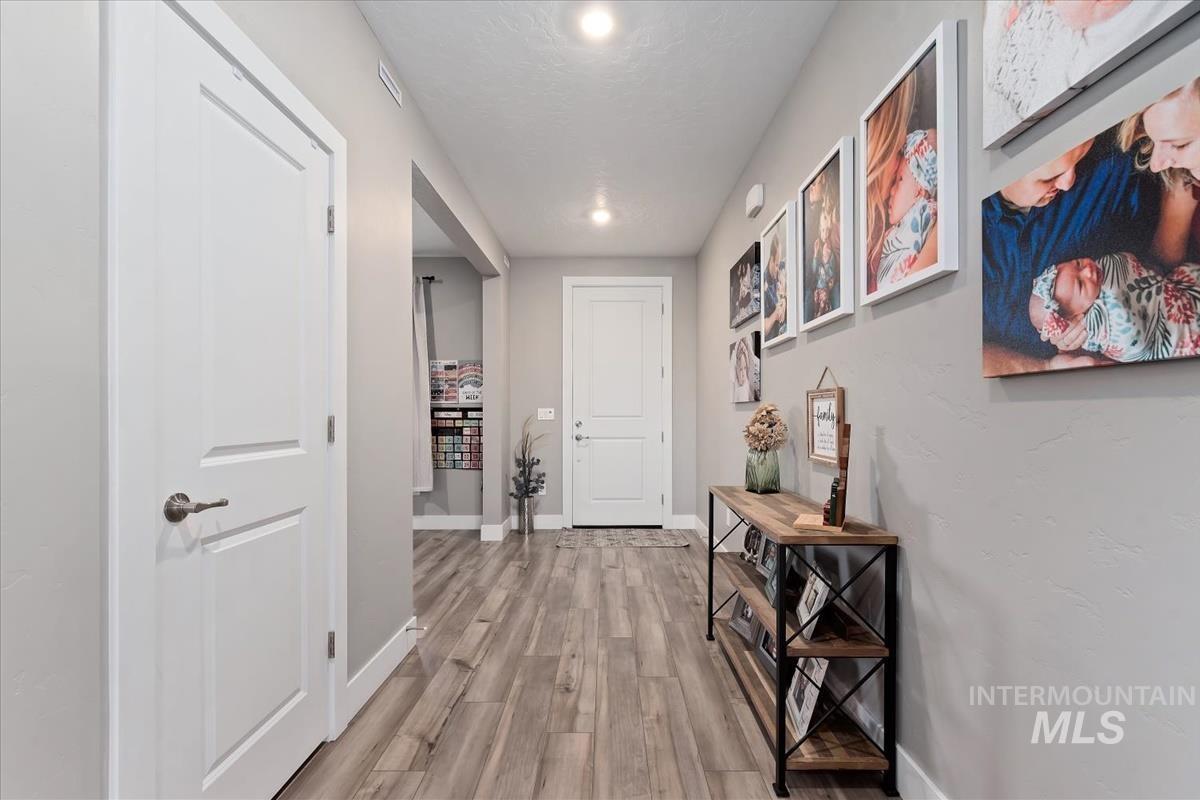 815 Knowledge Street Middleton, ID 83644 - Photo 5 of 49 Bright hallway featuring wood-finish flooring, light gray walls, white trim, and recessed lighting