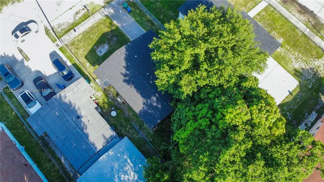 an aerial view of residential houses with outdoor space and parking