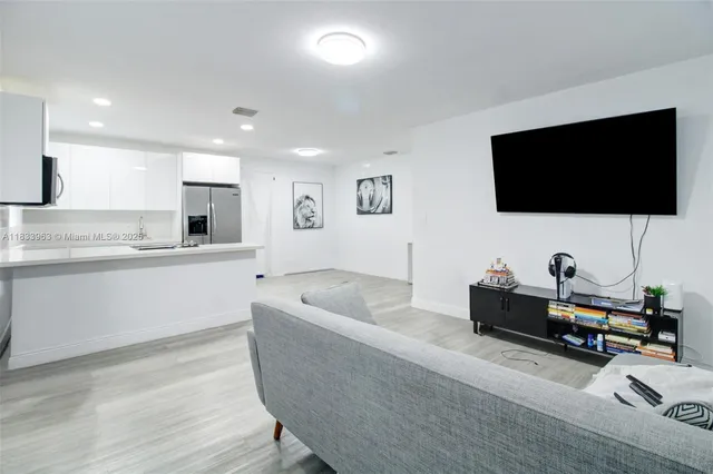 a view of a hallway to room with wooden floor and stairs