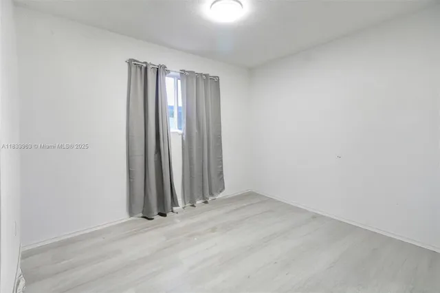 a bedroom with a bed and a flat tv screen on a dresser