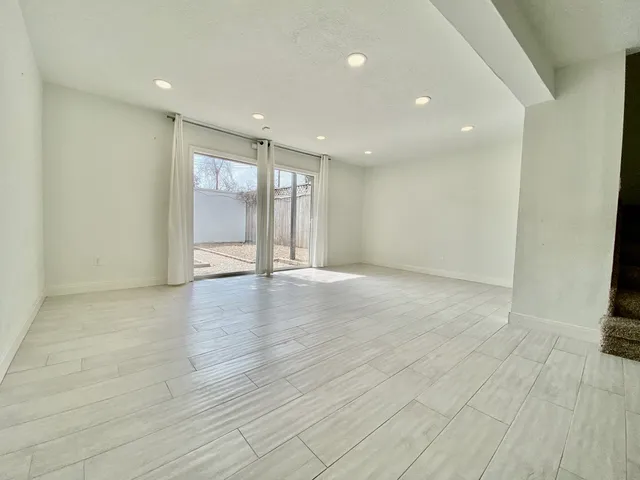 a view of an empty room with wooden floor and closet