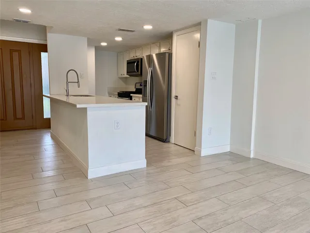 a kitchen with granite countertop a refrigerator and a sink