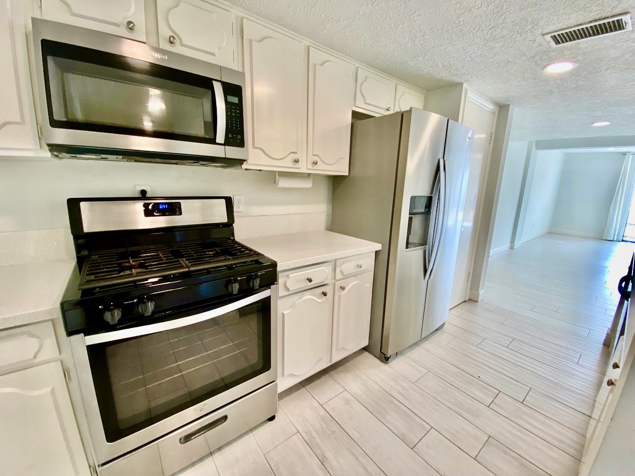 1259 Blalock Road Houston, TX 77055 - Photo 10 of 41 a kitchen with stainless steel appliances a stove a microwave and cabinets