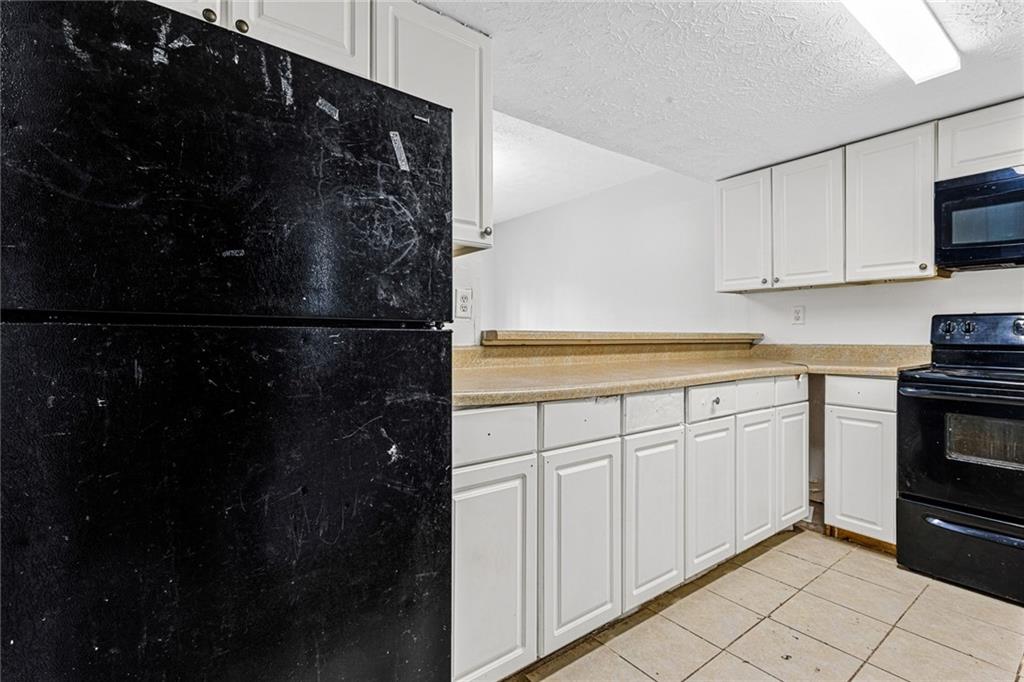 3451 Cobbs Ferry Drive Decatur, GA 30032 - Photo 5 of 21 a kitchen with white cabinets and black appliances